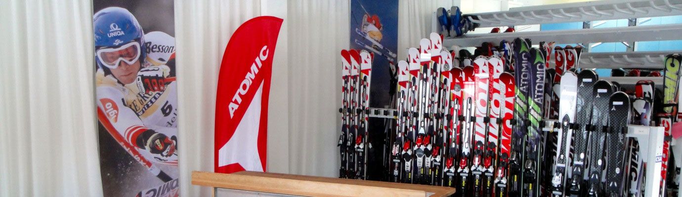 Ski rental with Atomic skis and advertising banner.
