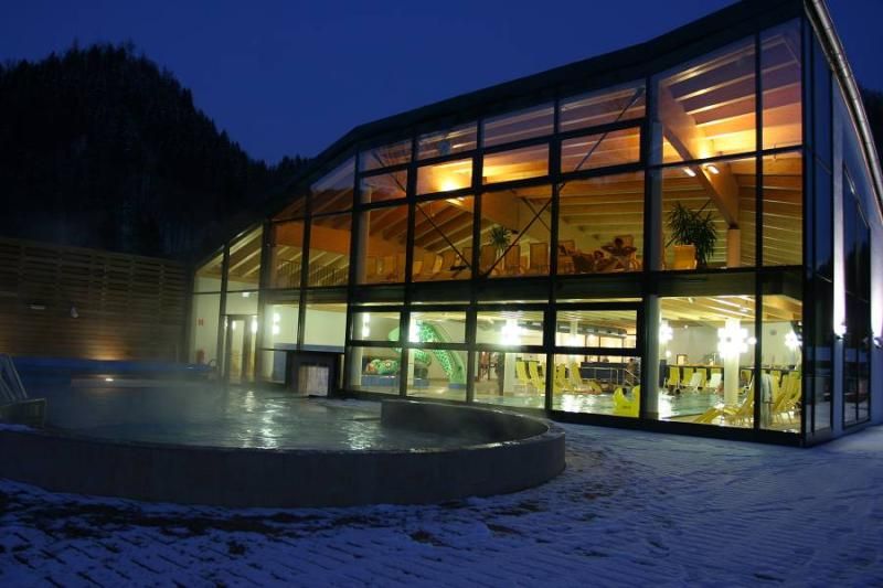 Exterior view of the Ybbstaler Solebad Göstling at night with illuminated indoor area.