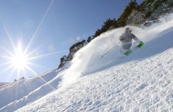 Ein Skifahrer gleitet elegant durch den frischen Pulverschnee, während die strahlende Sonne über den schneebedeckten Gipfeln leuchtet. Die unberührte Landschaft und die klare Luft schaffen eine unvergleichliche Atmosphäre für Freeride-Enthusiasten. Hier, im Großen Kar, wird jeder Schwung zu einem unvergesslichen Erlebnis.