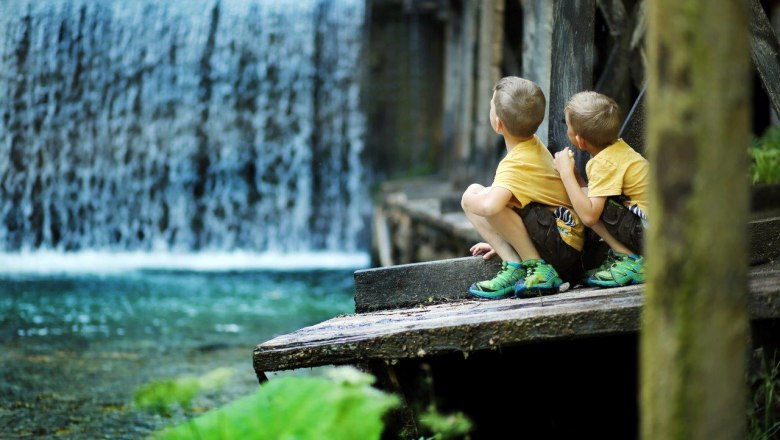 Two boys watch the falling water.