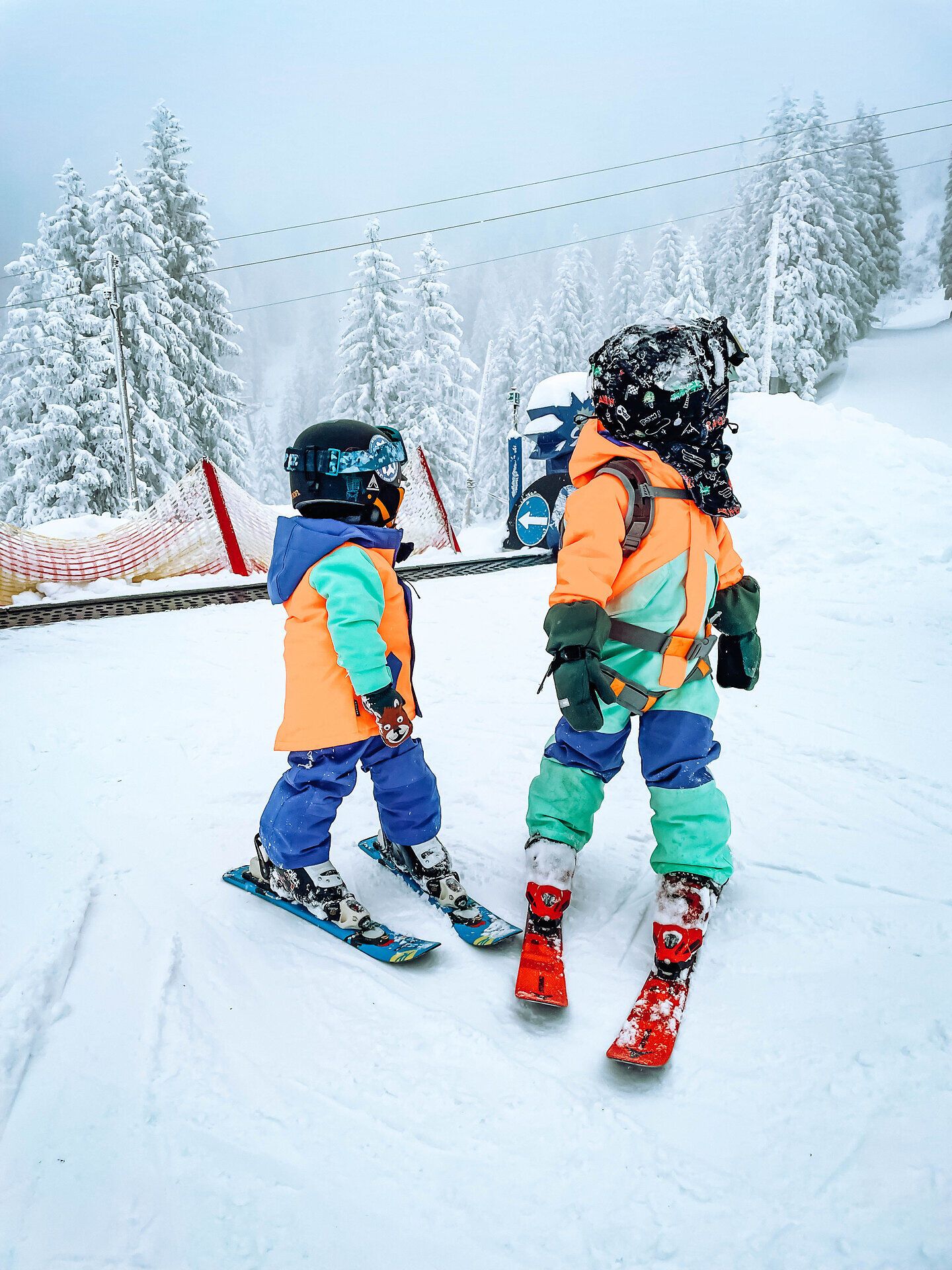Zwei fröhliche Kinder gleiten mit ihren Skiern über die schneebedeckten Pisten, umgeben von einer traumhaften Winterlandschaft. Die frische, kalte Luft und die glitzernden Schneekristalle schaffen eine magische Atmosphäre, die zum Spielen und Entdecken einlädt.