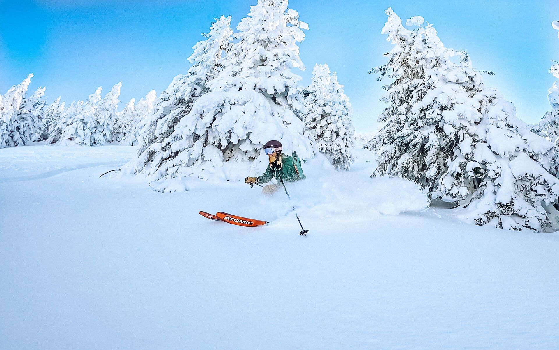 Inmitten einer traumhaften Winterlandschaft gleitet eine Familie durch den frischen, pulvrigen Schnee. Die schneebedeckten Bäume umrahmen die Szenerie und schaffen eine magische Atmosphäre, die zum Verweilen einlädt. Hier wird der Winter zum unvergesslichen Erlebnis für Groß und Klein.
